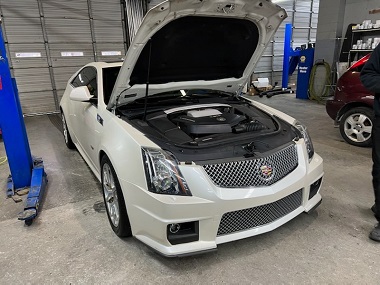 Cadillac CTS with hood up in service garage